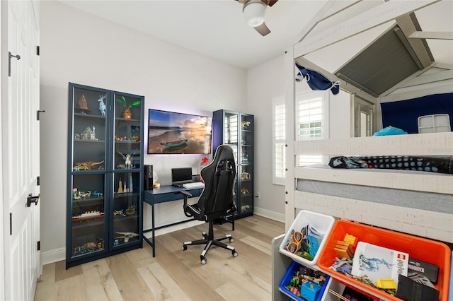 office area featuring a ceiling fan, baseboards, vaulted ceiling, and wood finished floors