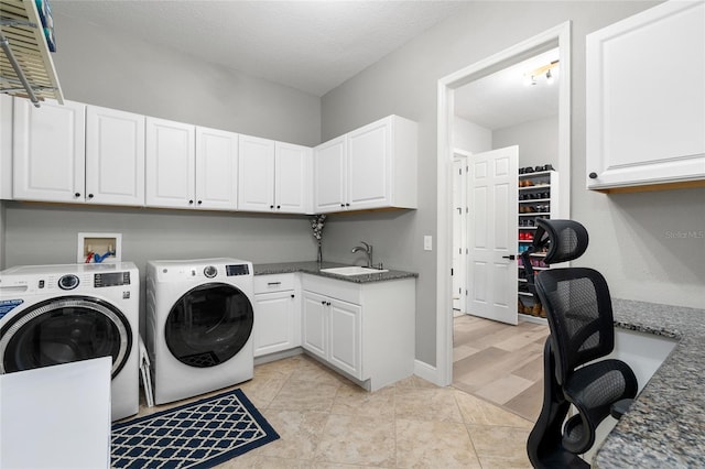 clothes washing area with cabinet space, separate washer and dryer, baseboards, and a sink