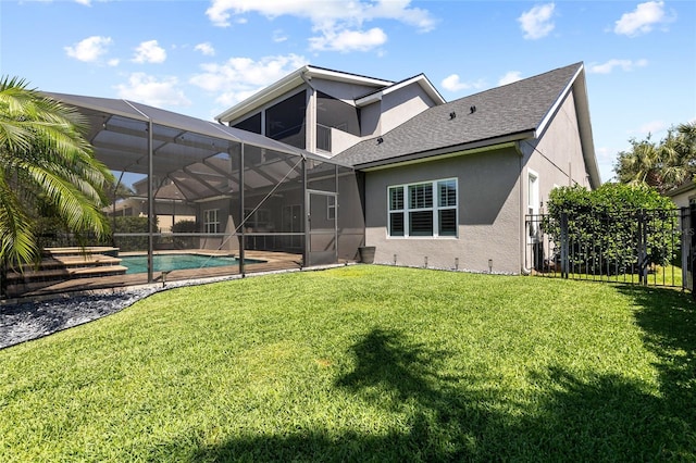 rear view of house with an outdoor pool, fence, a yard, a shingled roof, and stucco siding