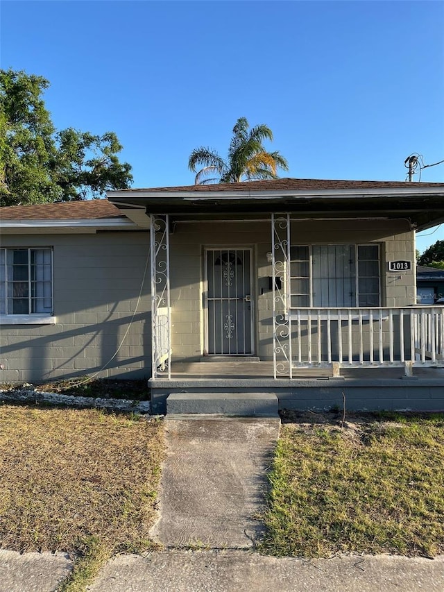 view of front facade with concrete block siding and a porch