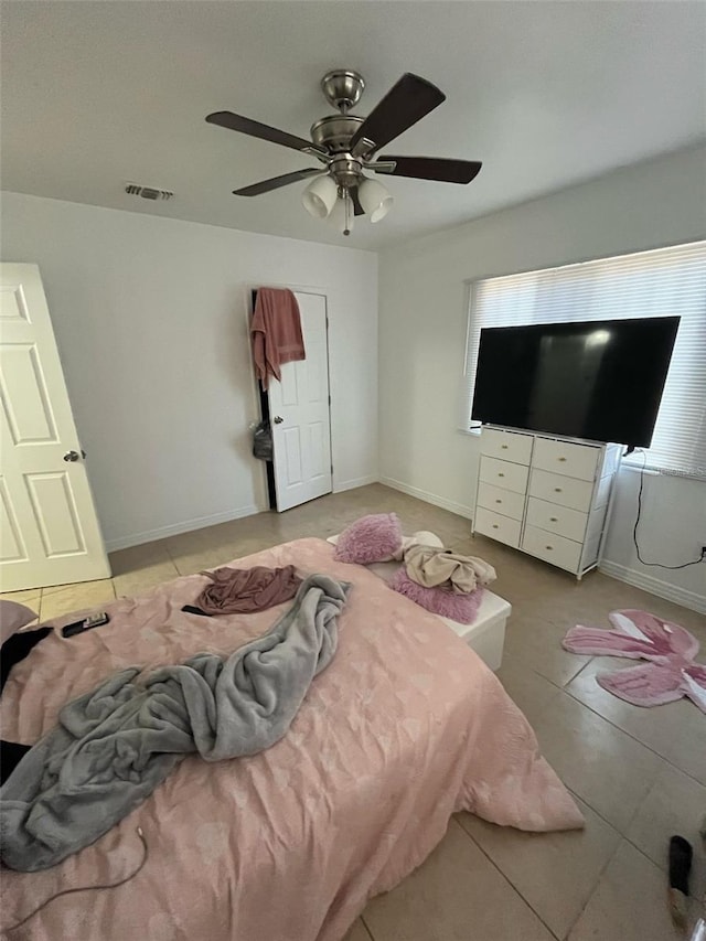 tiled bedroom featuring a ceiling fan, baseboards, and visible vents