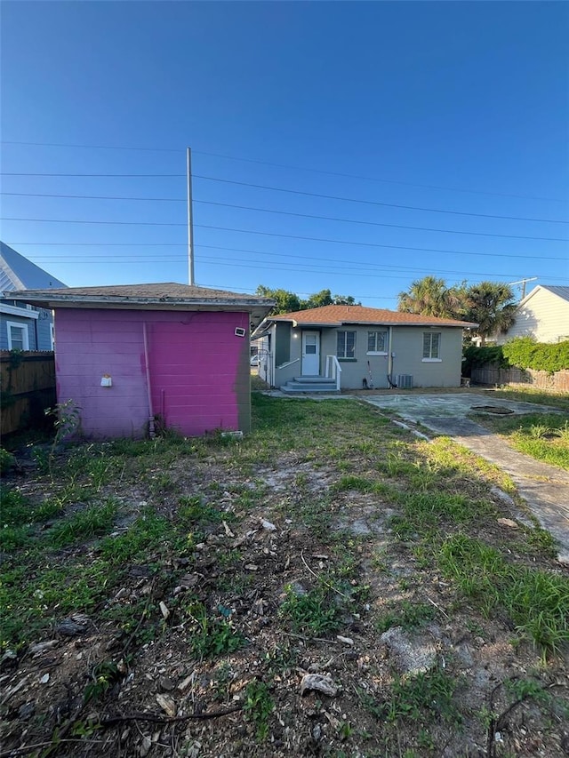 back of property with fence and an outdoor structure