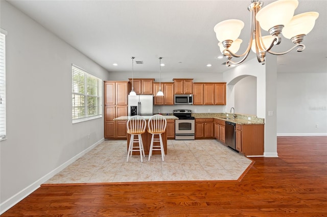 kitchen featuring arched walkways, a sink, recessed lighting, a chandelier, and appliances with stainless steel finishes