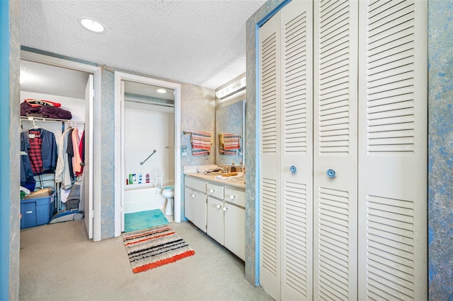 1 Key Capri Unit 608E, Treasure Island, FL 33706 - corridor featuring a textured ceiling, light carpet, and a sink
