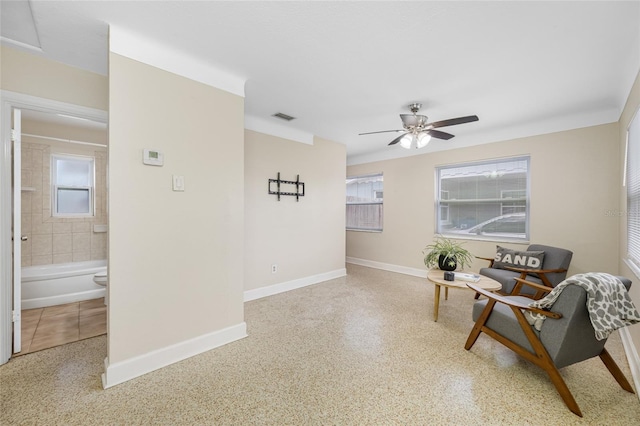 living area with visible vents, baseboards, and a healthy amount of sunlight