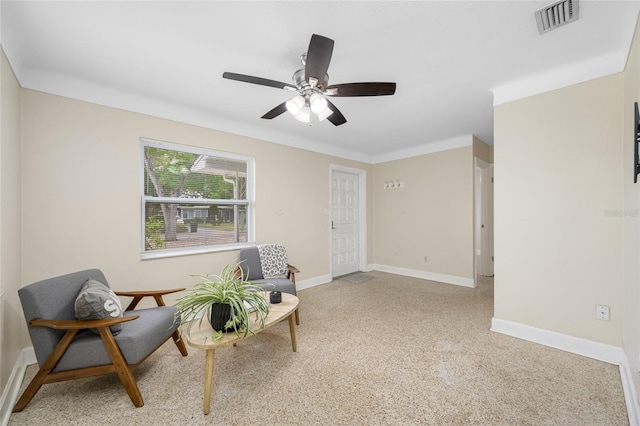living area featuring visible vents, baseboards, and ceiling fan