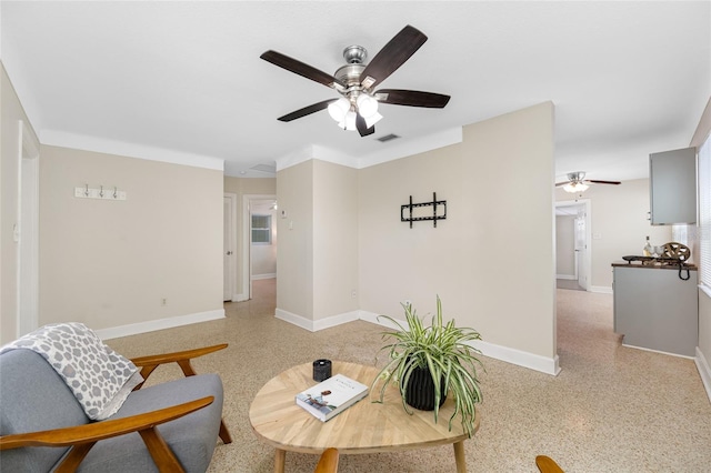 living room with baseboards, a ceiling fan, visible vents, and light speckled floor