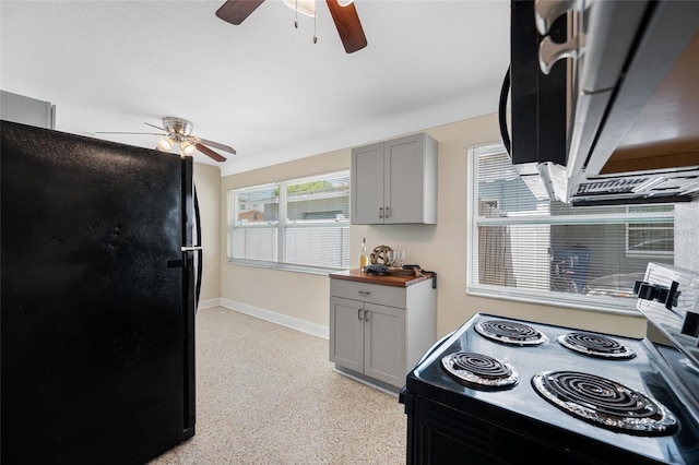 kitchen featuring range with electric cooktop, light speckled floor, gray cabinets, freestanding refrigerator, and ceiling fan