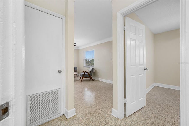corridor with light speckled floor, visible vents, and baseboards