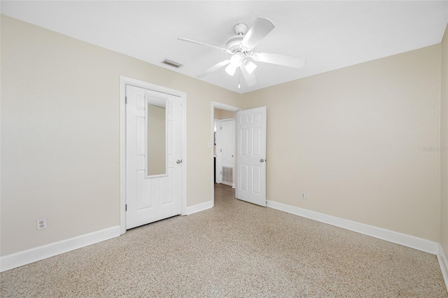 unfurnished bedroom with speckled floor, visible vents, a ceiling fan, and baseboards