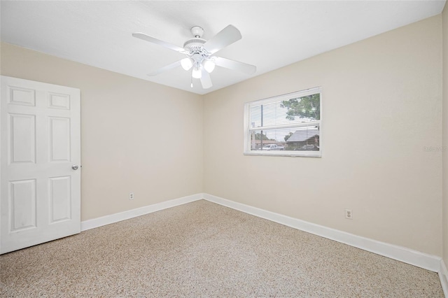 empty room with speckled floor, baseboards, and ceiling fan