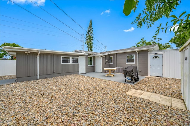 rear view of house featuring a patio area, central AC unit, and fence