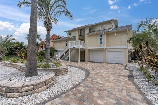 view of front of property with stairway, a garage, and decorative driveway