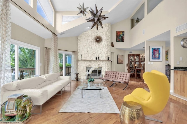 living room featuring a high ceiling, wood finished floors, and a fireplace