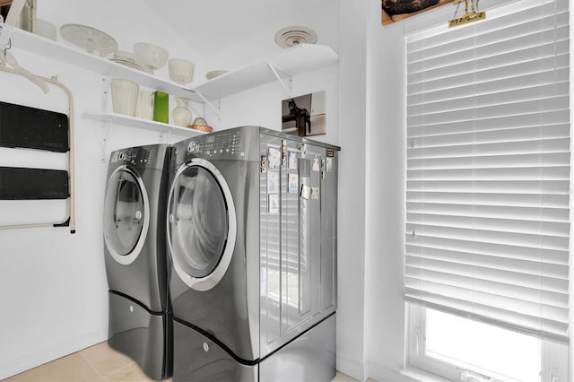 washroom with washing machine and clothes dryer and light tile patterned floors