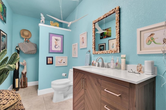 bathroom with tile patterned floors, toilet, vanity, and baseboards