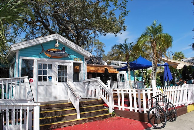 view of front of house featuring fence and a deck