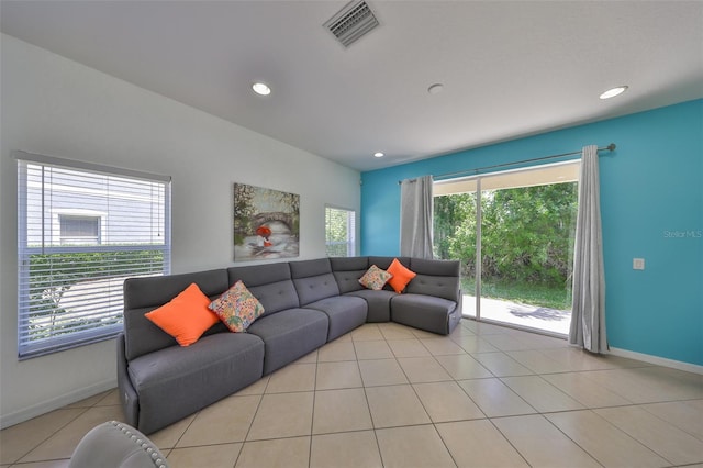 living room with a wealth of natural light, tile patterned flooring, visible vents, and recessed lighting