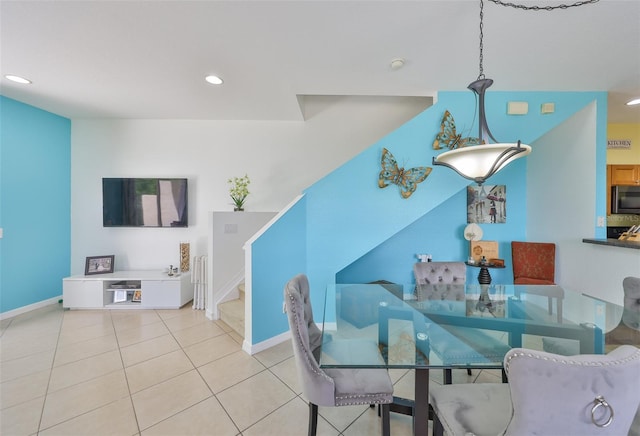tiled dining space with baseboards, recessed lighting, and stairway