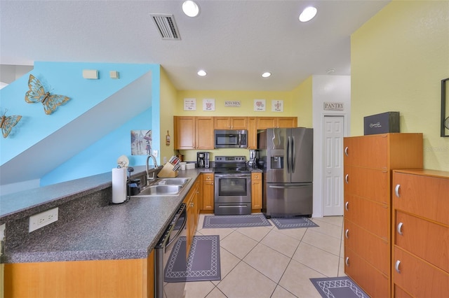 kitchen with stainless steel appliances, dark countertops, visible vents, a sink, and a peninsula