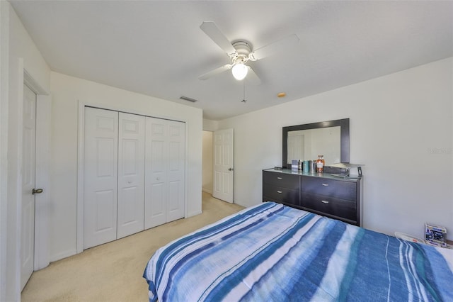 bedroom featuring a closet, visible vents, light colored carpet, and ceiling fan