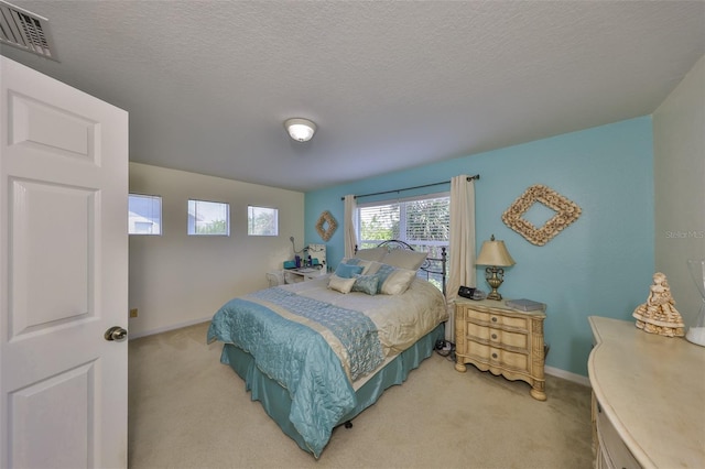 bedroom with light carpet, visible vents, and baseboards