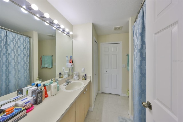 bathroom featuring baseboards, vanity, tile patterned floors, and visible vents