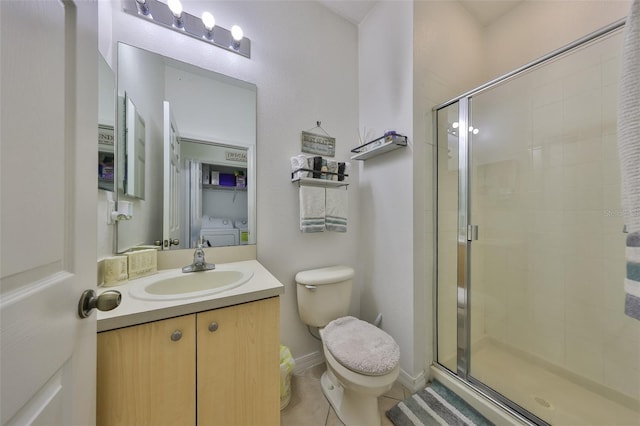 bathroom featuring washing machine and clothes dryer, tile patterned floors, toilet, a shower stall, and vanity