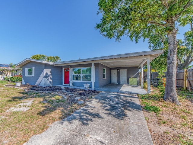 11397 122nd Ave, Largo, FL 33778 - view of front facade with fence, concrete block siding, concrete driveway, and an attached carport
