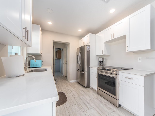 11397 122nd Ave, Largo, FL 33778 - kitchen featuring stainless steel appliances, a sink, light countertops, white cabinetry, and recessed lighting
