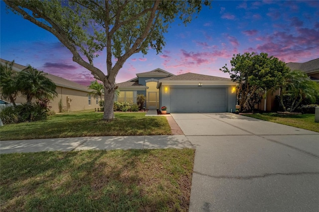 ranch-style home with concrete driveway, stucco siding, a front lawn, and a garage