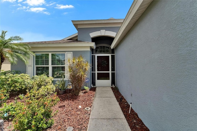 view of exterior entry featuring stucco siding