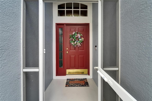 entrance to property featuring stucco siding