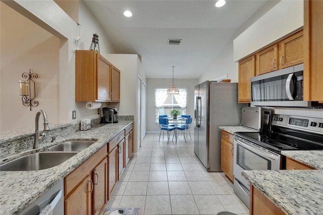 kitchen with appliances with stainless steel finishes, light stone counters, a sink, light tile patterned floors, and visible vents