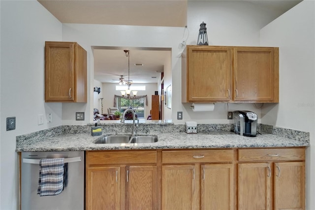 kitchen featuring stainless steel dishwasher, light stone counters, a sink, and an inviting chandelier