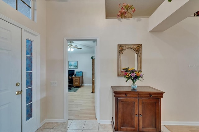 entryway featuring light tile patterned flooring, baseboards, and a ceiling fan