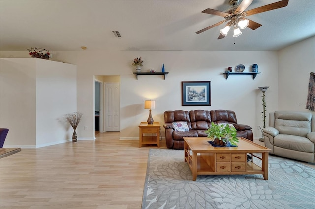 living area with a ceiling fan, baseboards, visible vents, and light wood-style floors