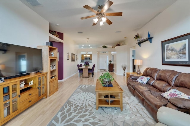 living area with baseboards, a ceiling fan, light wood-type flooring, and visible vents