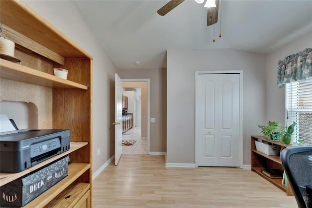 home office with baseboards, a ceiling fan, and light wood-style flooring