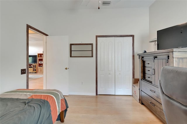 bedroom with a closet, baseboards, visible vents, and light wood-type flooring
