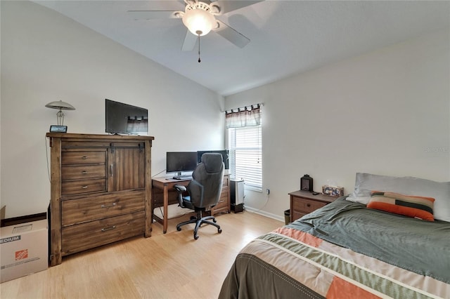 bedroom with baseboards, a ceiling fan, light wood-style flooring, and vaulted ceiling