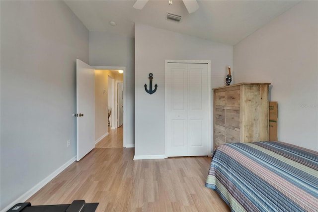 bedroom with visible vents, baseboards, light wood finished floors, and lofted ceiling