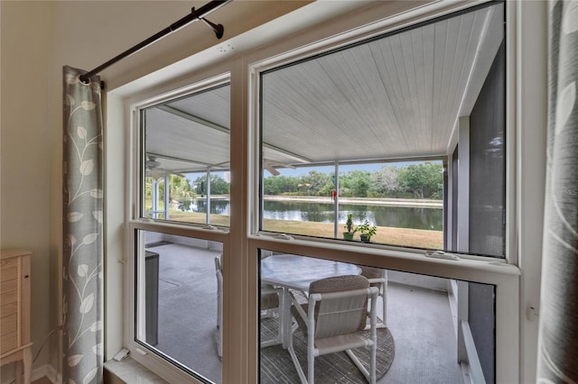 interior space with carpet floors, a water view, and a wealth of natural light