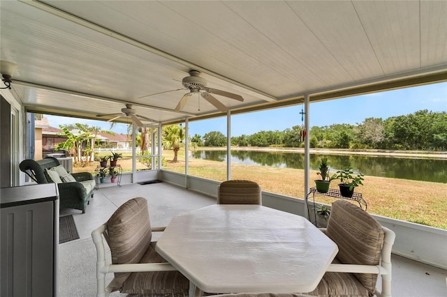 sunroom / solarium featuring a water view, a ceiling fan, and outdoor dining space