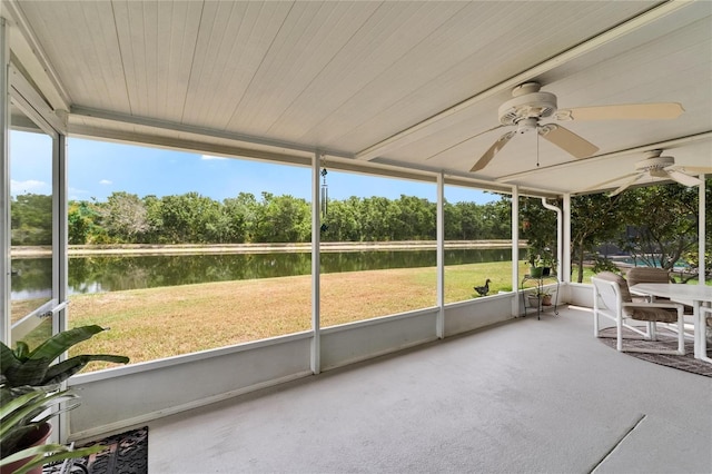unfurnished sunroom featuring a water view and a ceiling fan
