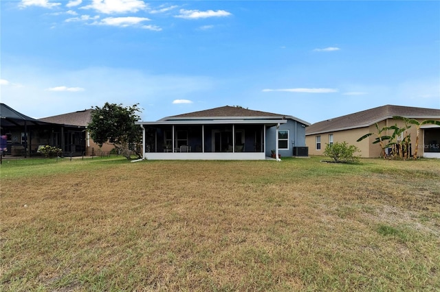 back of property with a sunroom, stucco siding, a yard, and cooling unit