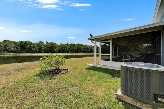 view of yard featuring a water view, a sunroom, and central AC