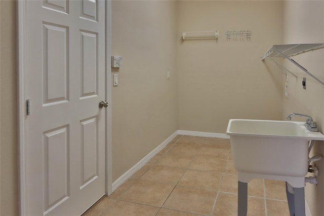 washroom featuring baseboards, laundry area, and light tile patterned floors