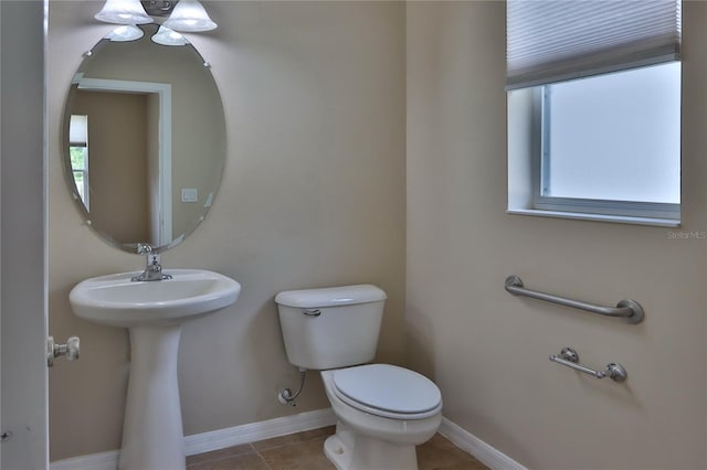 bathroom with baseboards, toilet, tile patterned floors, and plenty of natural light
