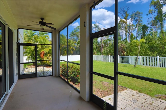 unfurnished sunroom featuring ceiling fan